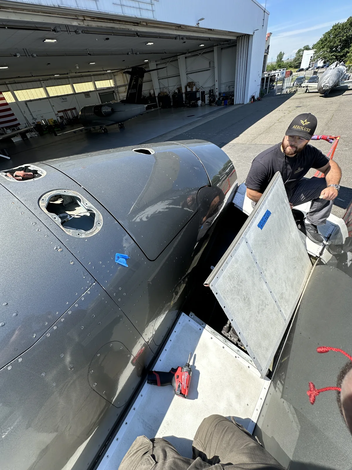 Technician working at an open engine-access panel.